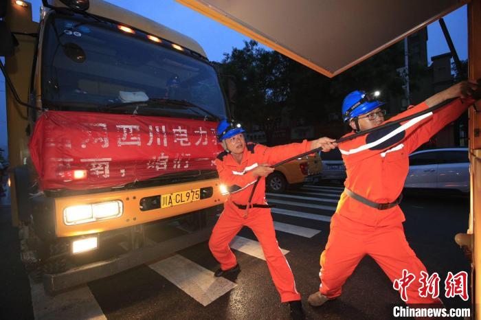 国网四川省电力公司援豫抢险队接入应急发电车，保障居民正常生活用电。　田海 摄