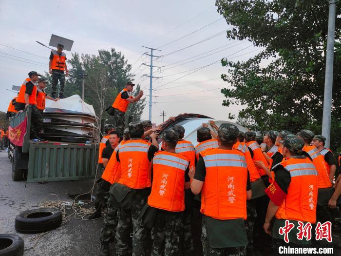 图为武警河南总队机动支队官兵正把船放入水中，准备乘船去堤坝处。　杨大勇 摄