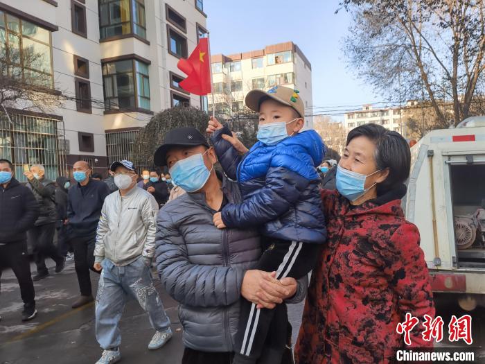 图为火电小区居民手拿国旗庆祝解封。　祁增蓓 摄