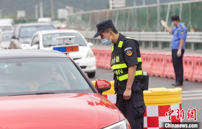 工作人员在对驾乘人员进行挨个查验。　泱波 摄