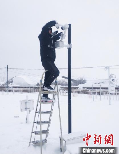 公主岭市气象局业务人员风雪中维护气象观测设备。　吉林省气象局供图