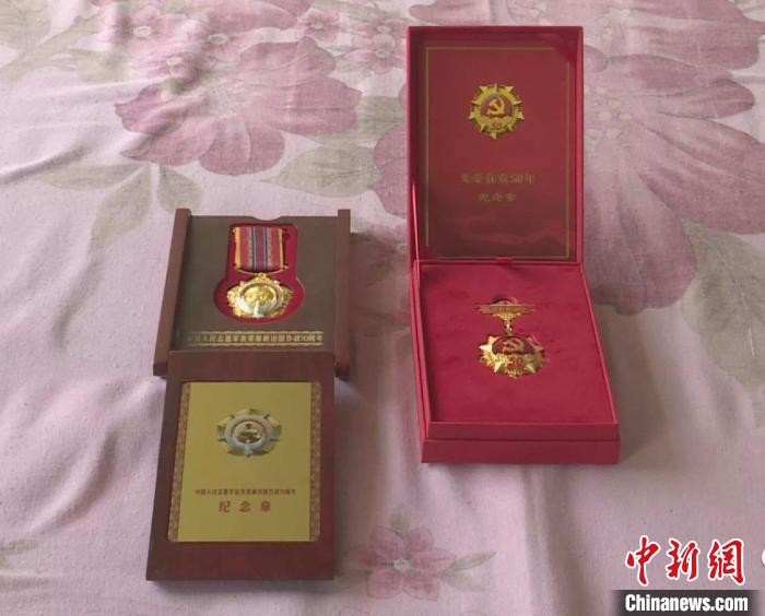 刘玉生从抽屉里取出一个红色小包，里面装着各种纪念章。　和顺县融媒体中心供图