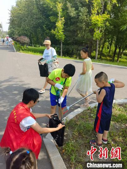 “环保小卫士”在长春伊通河堤岸捡拾垃圾。