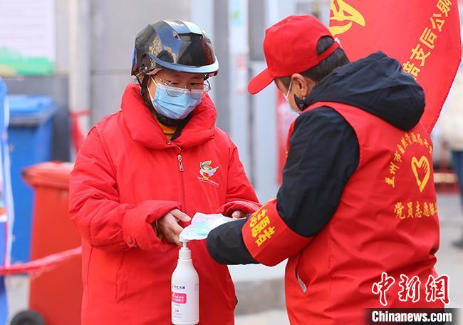 作为三个孩子的妈妈，牛宏玉(左)顾不得才刚满两岁的宝宝，每天驻守岗位引导大家做好一级防护，带好口罩。　高展 摄