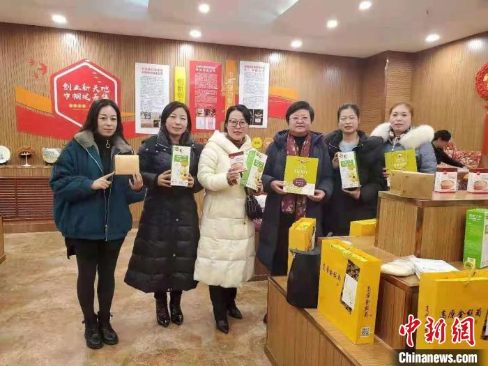 图为刘军梅(左三)和同事展示农产品。(资料图) 受访人供图