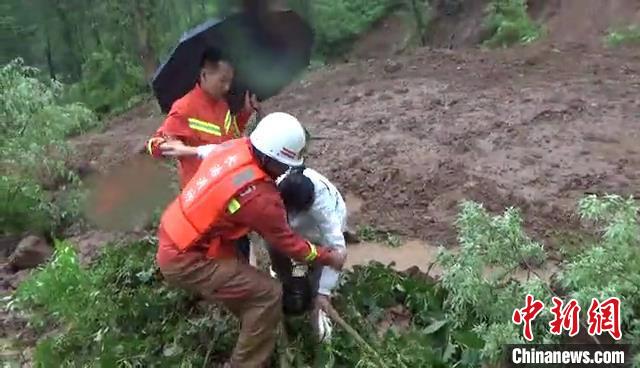 消防员接力保护被困村民踩着独木桥通过淤泥地带。　黎城消防供图