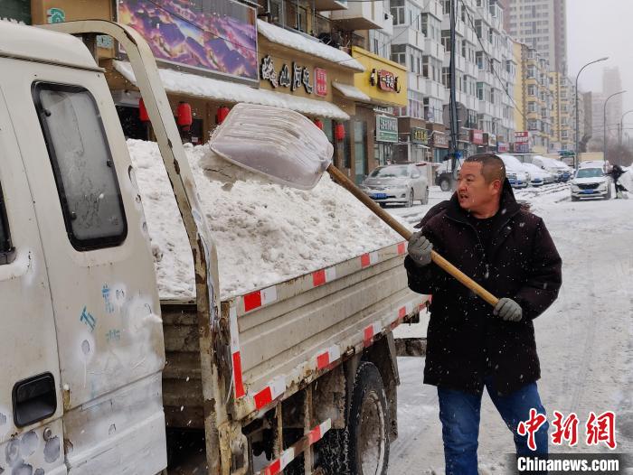 清雪人员清运积雪。　姜辉 摄