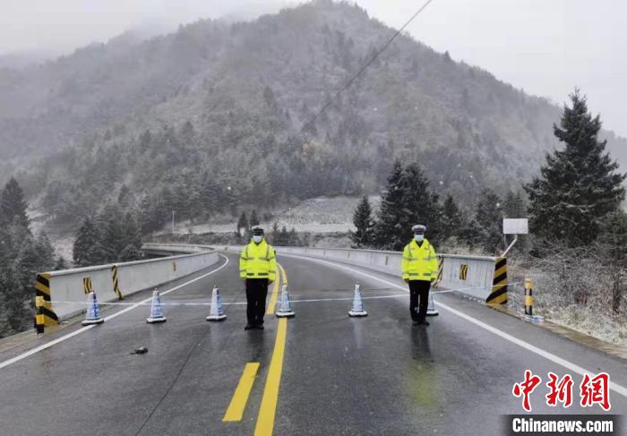 11月6日，甘肃省陇南市宕昌县交警队执勤人员冒雪在省道209线南河南腊公路疫情防控执勤点执勤。　刘辉 摄