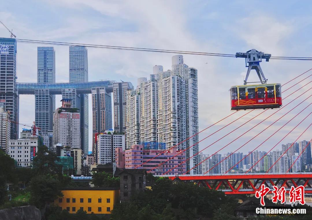 图为在白象居3号楼连廊处，游客可欣赏到长江索道与东水门长江大桥、湖广会馆、远处的来福士等城市建筑同框画面。殷缘 摄