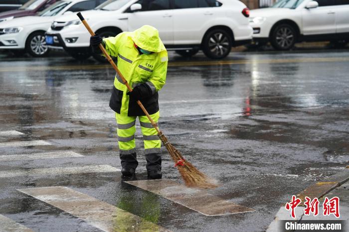 环卫人员冒雨打扫街路。　孙汉仑 摄