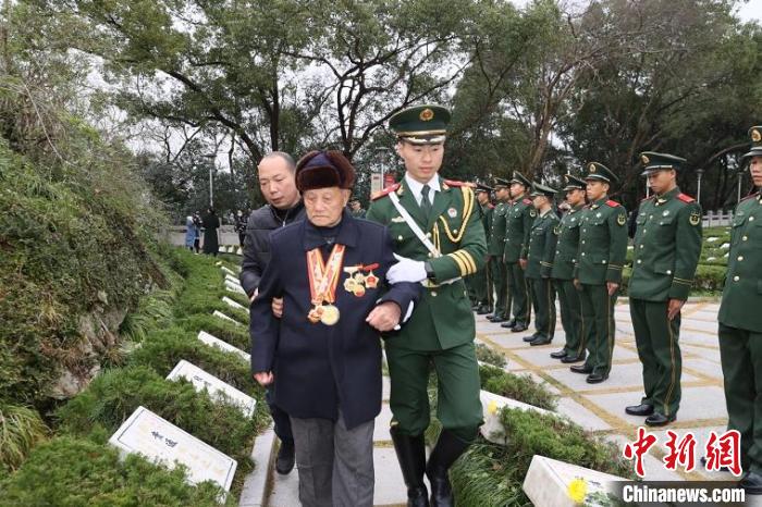 武警官兵搀扶着老兵祭扫烈士陵园 章朝晖 摄