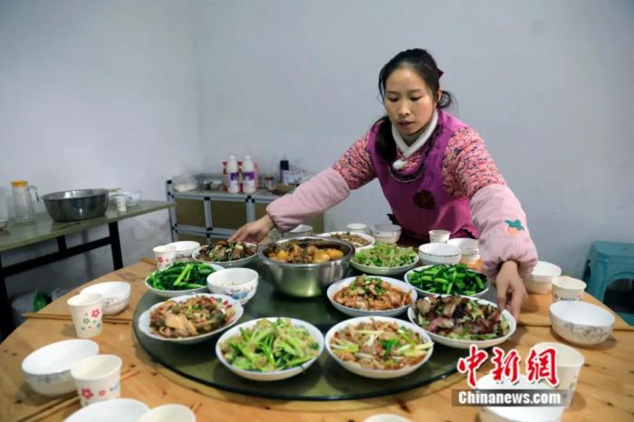 桃子姐将做好的饭菜端上餐桌。王磊 摄