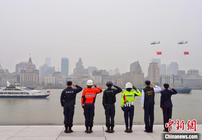 图为两架悬吊着巨幅国旗和警旗的警务直升机飞过外滩万国建筑群。　上海警方供图