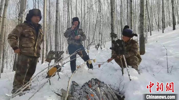 图为中午，林业工人们点起一堆火，将馒头、腌肉、鸡蛋串成串放在火上烤热，作为午餐。　何康红 摄