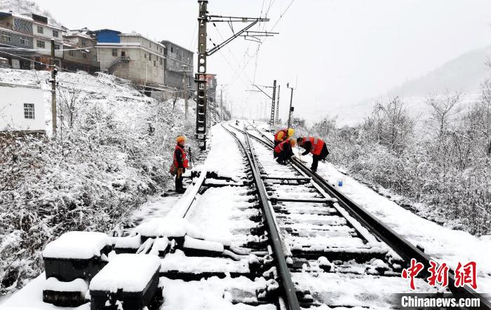 峨眉车务段突击队员正抓紧清理铁轨积雪等。　李勇 摄