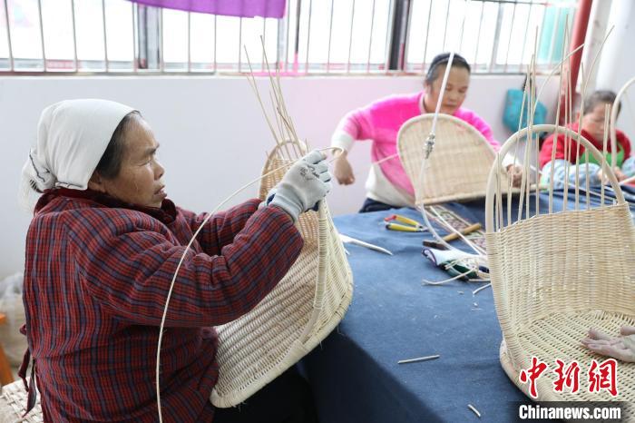 图为江川残疾人集中就业基地，工人编织藤椅。　龚普康 摄