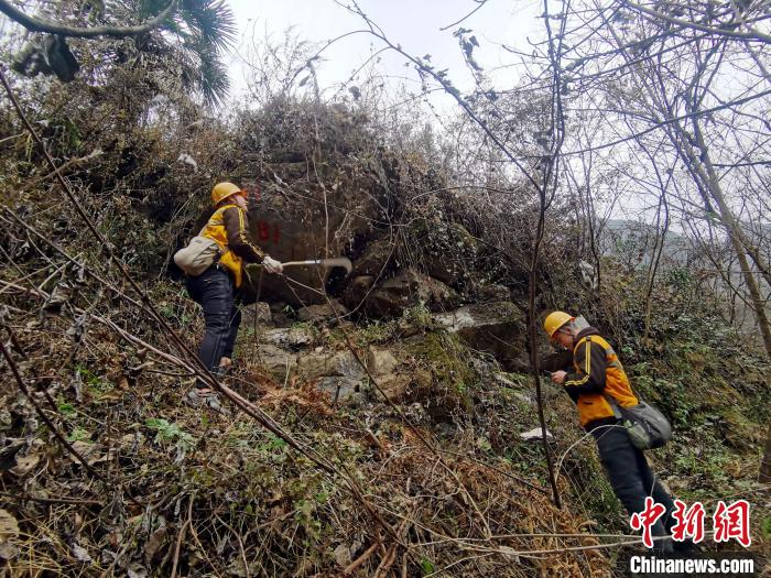 图为工作人员在半山腰上标记岩石。　马瑜阳 摄