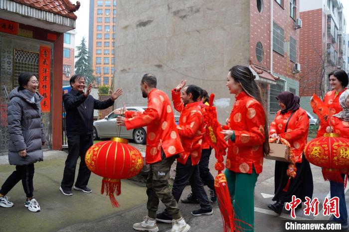 长期居住在鸡鸣山社区的外籍人士到达该社区居民刘樟根家楼下，送上节日的祝福。　董易鑫 摄