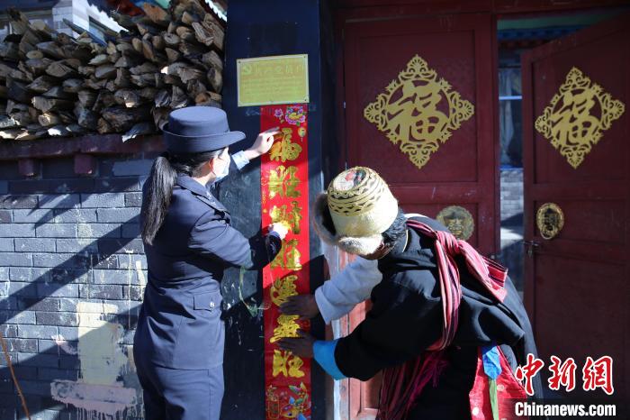 图为吉隆边检站女警扎西卓玛在村民门前张贴对联。　龚涛 摄