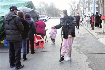 东丽区华明街第二社区党委书记、居委会主任刘云晶，不顾脚踝骨折，坚持来到二次核酸筛查采样点服务。 本报记者 刘国栋 摄