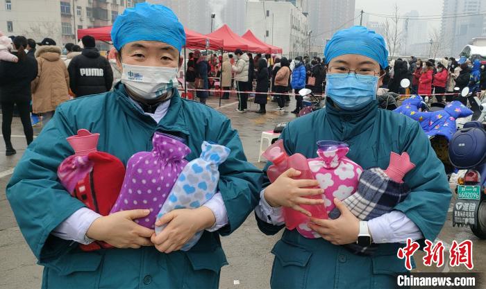 图为在核酸检测点，河南省肿瘤医院医护人员收到居民送的暖水袋。　河南省肿瘤医院供图