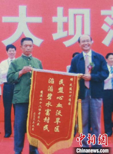 2006年9月，在黑龙凼水库大坝落成仪式上，吴正德(右一)代表民盟四川省接受库区百姓赠送锦旗。　张焰刚 摄