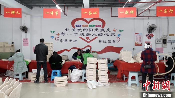 江川残疾人集中就业基地里工人编织藤椅。　王以照 摄