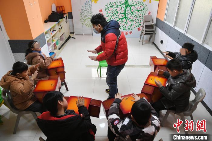 在合肥市蜀山区春语儿童康复中心教室内，岳雷给患有自闭症的学生上音乐课 韩苏原 摄