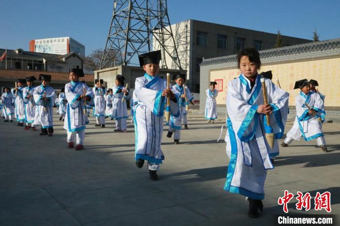 图为甘肃平凉市崆峒区八里小学学生身穿汉服，手拿毛笔道具表演节目。(资料图) 刘玉桃 摄