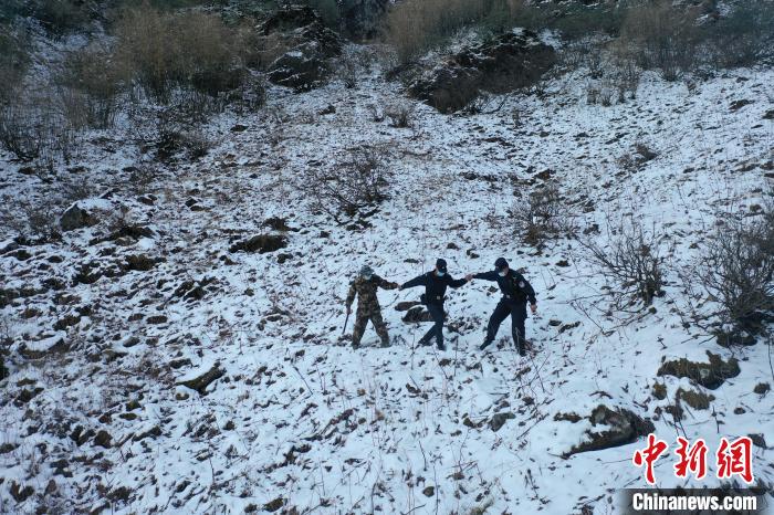 图为洛本卓边境派出所小垭口执勤点民警在雪山上巡逻。　怒江边境管理支队供图