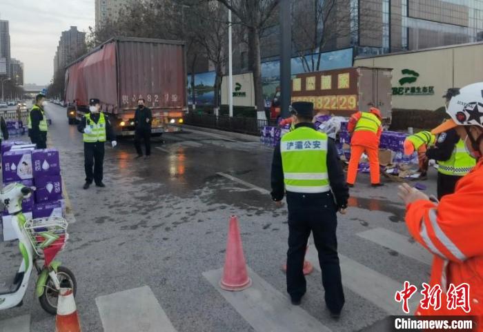 卡车倾斜物资散落一地，警民同心化身“搬运工”。　警方供图