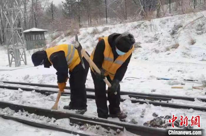 孙东伟带领职工在清除线路上的冰雪。　宋启明 摄