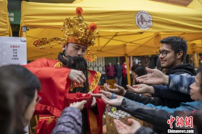 2020年1月，一位“财神”在旧金山“中国城”的春节花市上向市民散发礼品。中新社记者 刘关关 摄