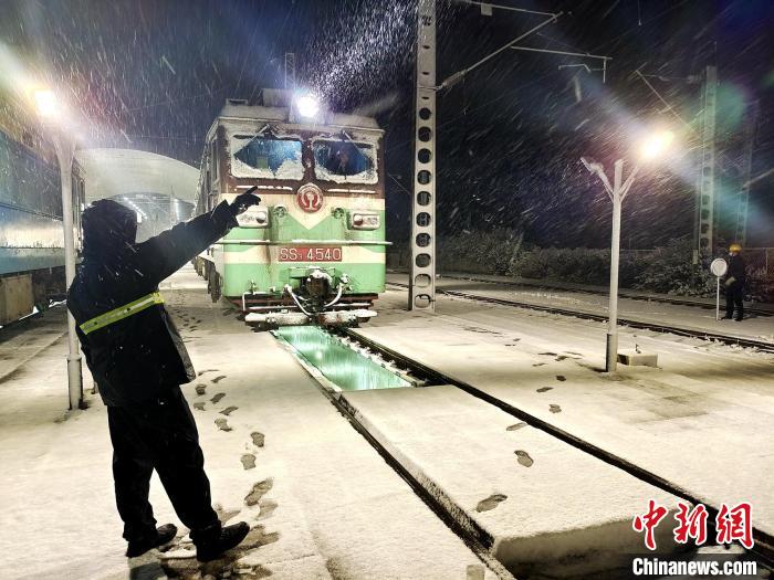 风雪中检查完毕的机车准备出库。　何超 摄