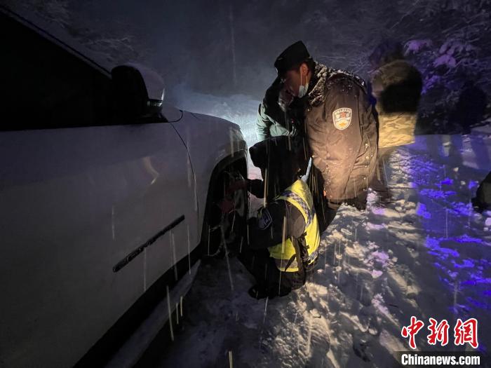 图为民警正在大雪中营救被困车辆。　怒江边境管理支队供图