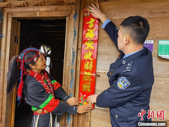 图为林芝达木边境派出所民警帮辖区民众贴春联。　王涛 摄