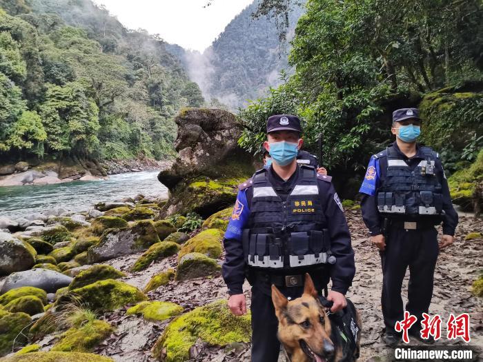 图为独龙江边境派出所民警与警犬“江豹”正在边境巡逻。　怒江边境管理支队供图。