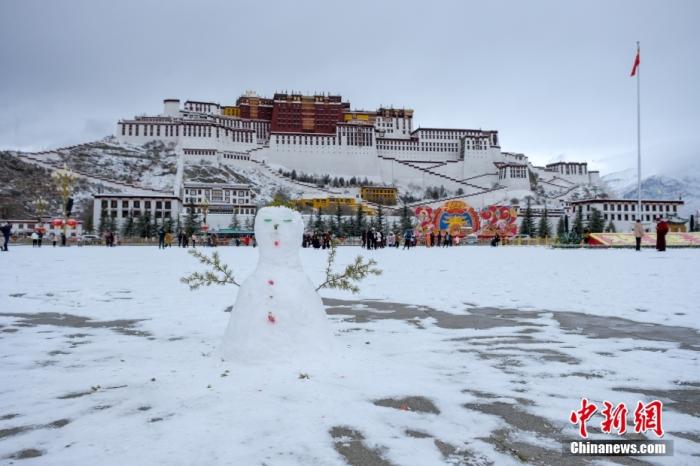 2月5日，拉萨布达拉宫广场上，用积雪堆的雪人。当日，西藏拉萨迎来大范围降雪，市民、游客踏雪出行。中新社记者 江飞波 摄