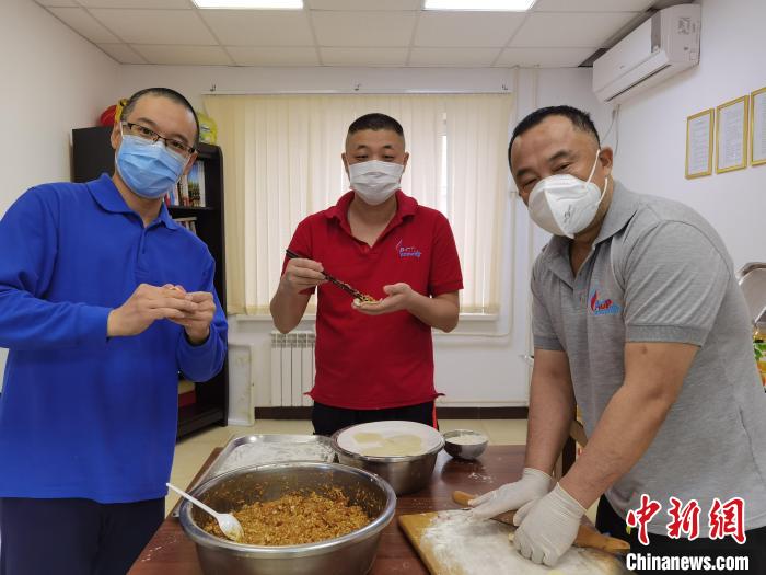 张彦华(中)与站上同事一起包饺子，庆祝团圆佳节。　受访者供图