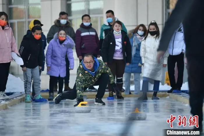 新疆伊宁市体育馆内一场冰壶比赛吸引众多市民争相打卡体验。顾晓霞 摄