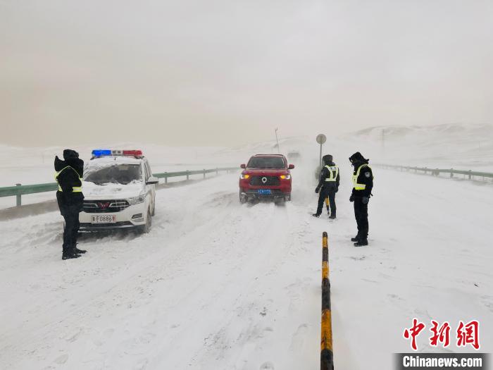 图为当地民警抗雪保畅。　玛多县委宣传部 供图