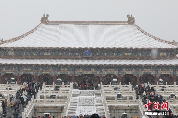 2月13日，北京迎来农历壬寅虎年首场降雪，民众在雪中游览故宫。 中新社记者 盛佳鹏 摄