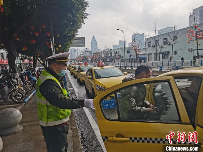 图为车安明(左一)在给旅客开车门。