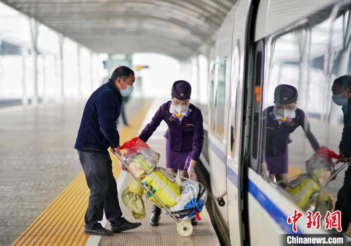 乘务员周亚娈在车门口帮助旅客上下车。　周围 摄