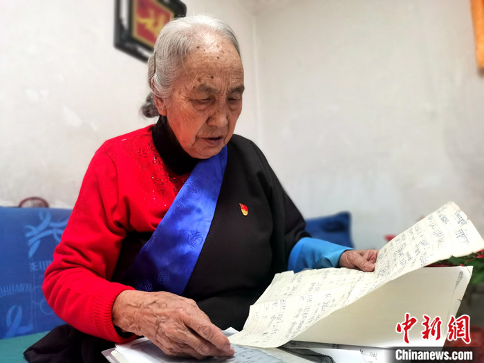 图为1月25日，青海省西宁市，年过八旬的藏族歌者秀日吉翻阅曲谱。 中新社记者 张添福 摄