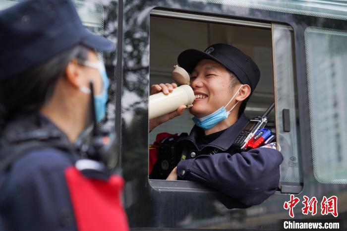 执勤间隙余艳玲为忙碌了一上午的刘柳送去热水。　张一凡 摄