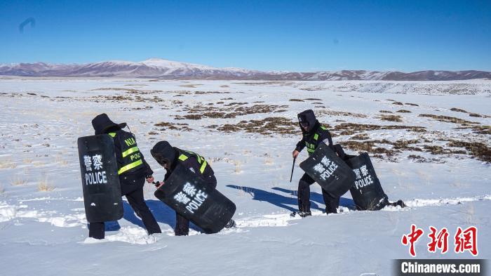 图为民警在齐腰的积雪中巡逻 。　西藏日喀则边境管理支队 摄