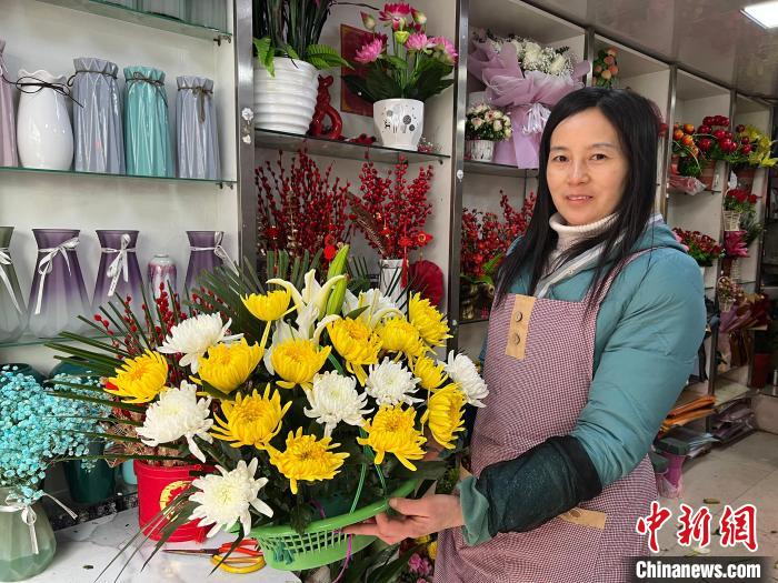 张洁心将菊花包装成各种花束和花篮供人们挑选。　储玮玮 　摄