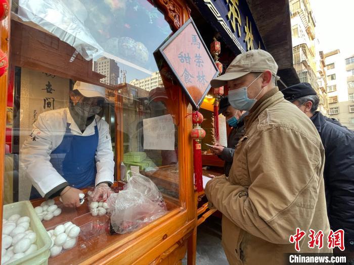 图为甜食店外排队等待的食客，由于供不应求，店里提示每人限购三斤。　高莹 摄