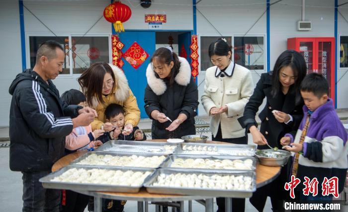 “贤内助”们带着孩子忙着准备除夕饺子。　刘忠俊 摄